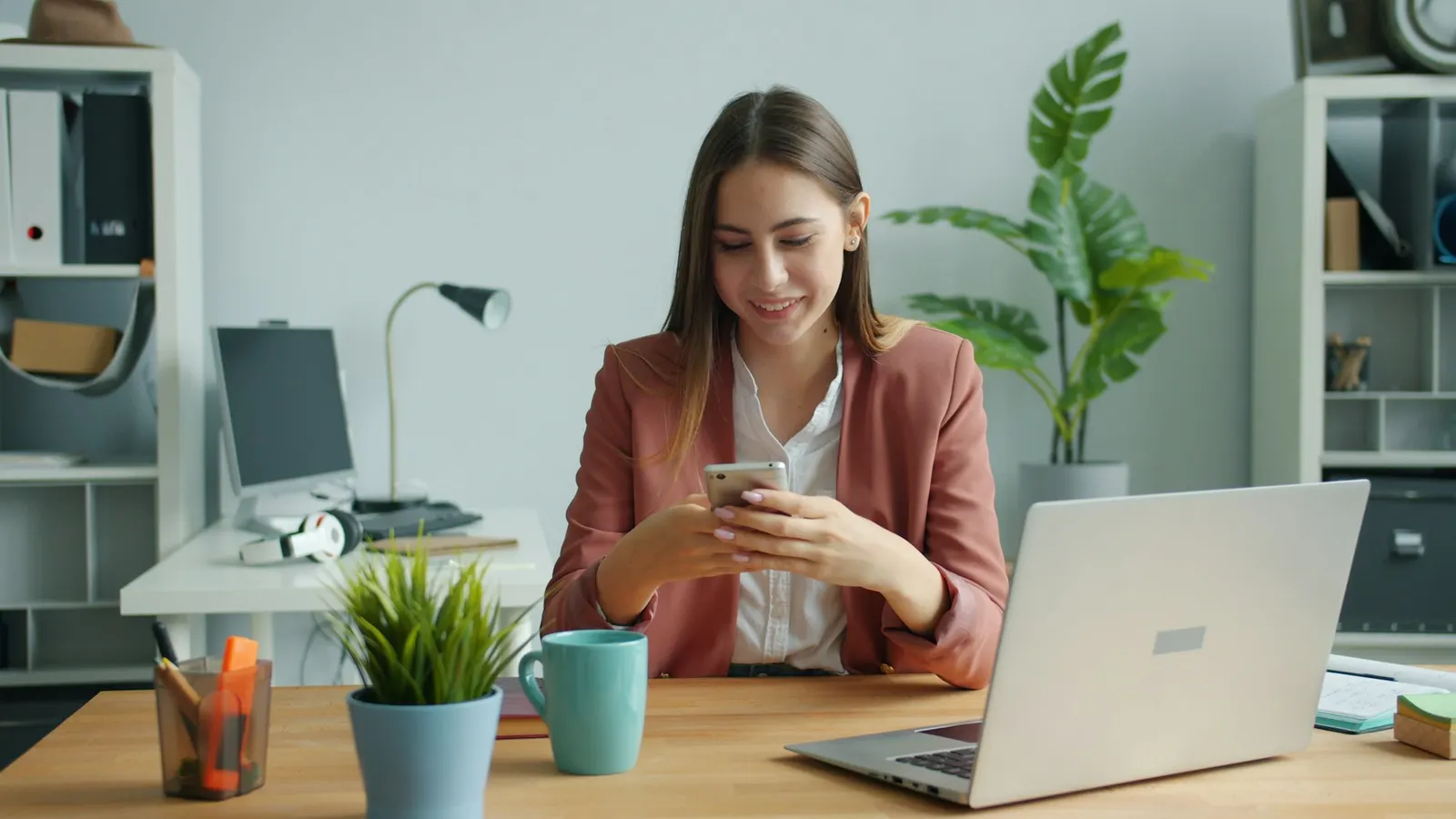 Atendente respondendo mensagens de clientes pelo celular na mesa de trabalho